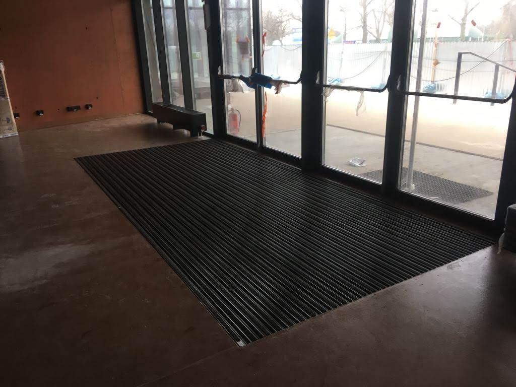 The entrance mat with ribbed carpet and rubber is installed in floor recesses in the entrance area inside the building.